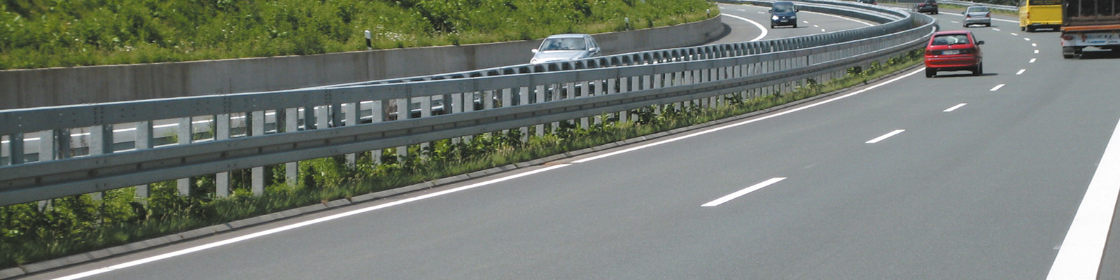Ein Teil einer Autobahn mit dem Fokus auf der Leitplanke.